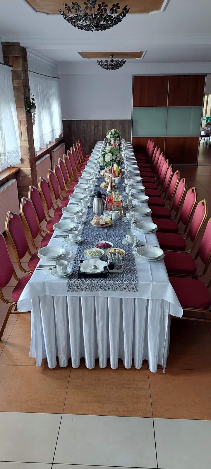 Długi stół nakryty do przyjęcia w sali