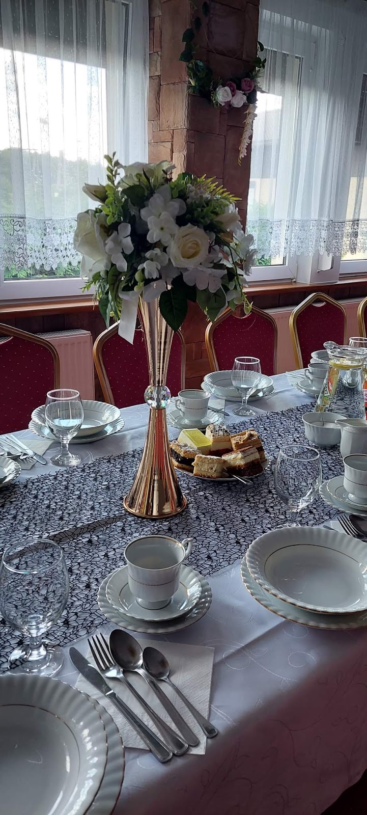 Elegancko nakryty stół ze złotym wazonem i ciastem